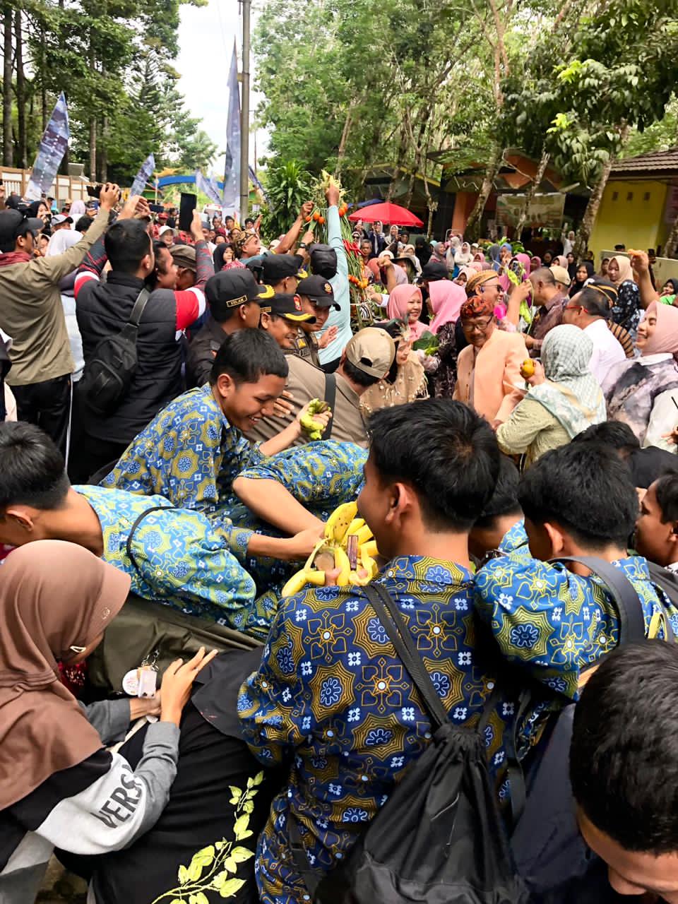 BEREBUT:Masyarakat, anak sekolah, dan wisatawan berebut hasil bumi yang dibawa orang kampung Sebelimbingan.