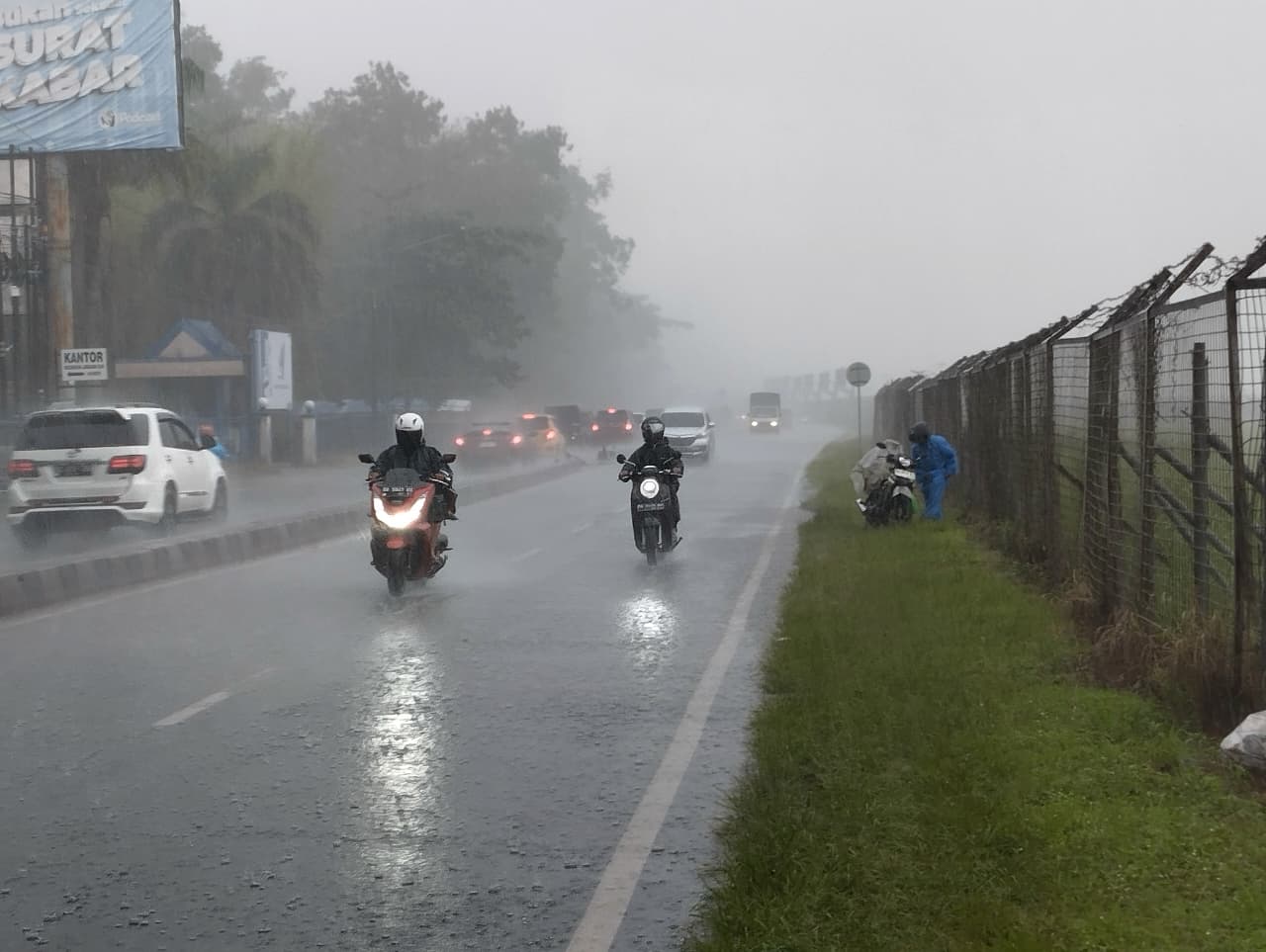 DERAS: Pengendara motor nekat menembus derasnya hujan di wilayah Landasan Ulin, Kota Banjarbaru.