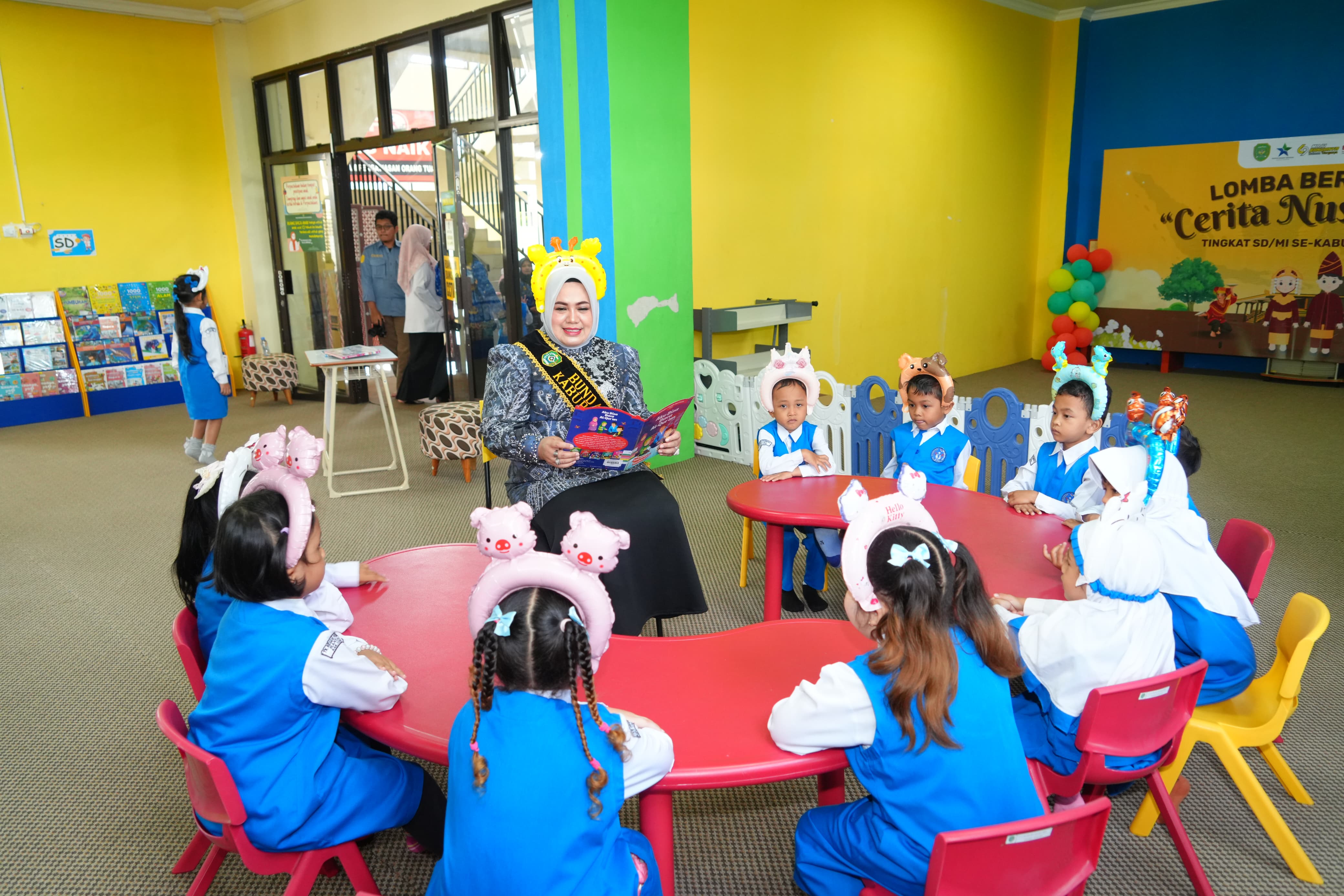 MEMBACA NYARING: Bunda Literasi Kabupaten Tapin Hj Faridah mempraktekkan membaca nyaring kepada para anak-anak.