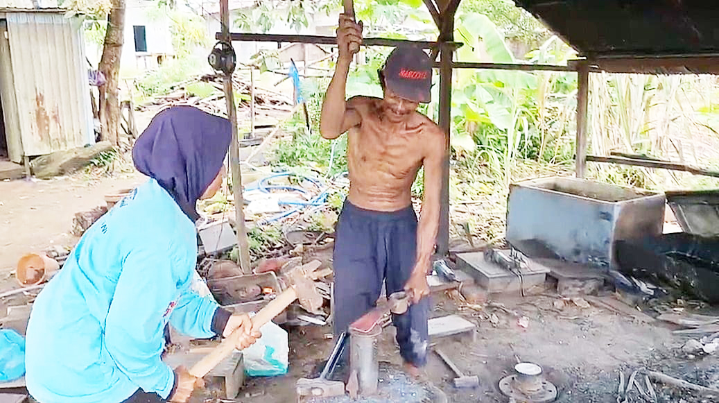 MENGOLAH: Wakidi bersama istrinya saat mengolah besi untuk membuat berbagai macam benda, Rabu (3/12).