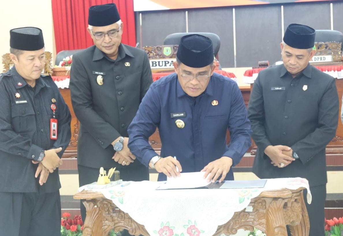 PENANDATANGANAN: Bupati HSU H Sahrujani saat menandatangani berita acara paripurna disaksikan kedua belah pihak baik legislatif dan eksekutif, bertempat di Aula Paripurna DPRD HSU, Kamis (4/12/2025).