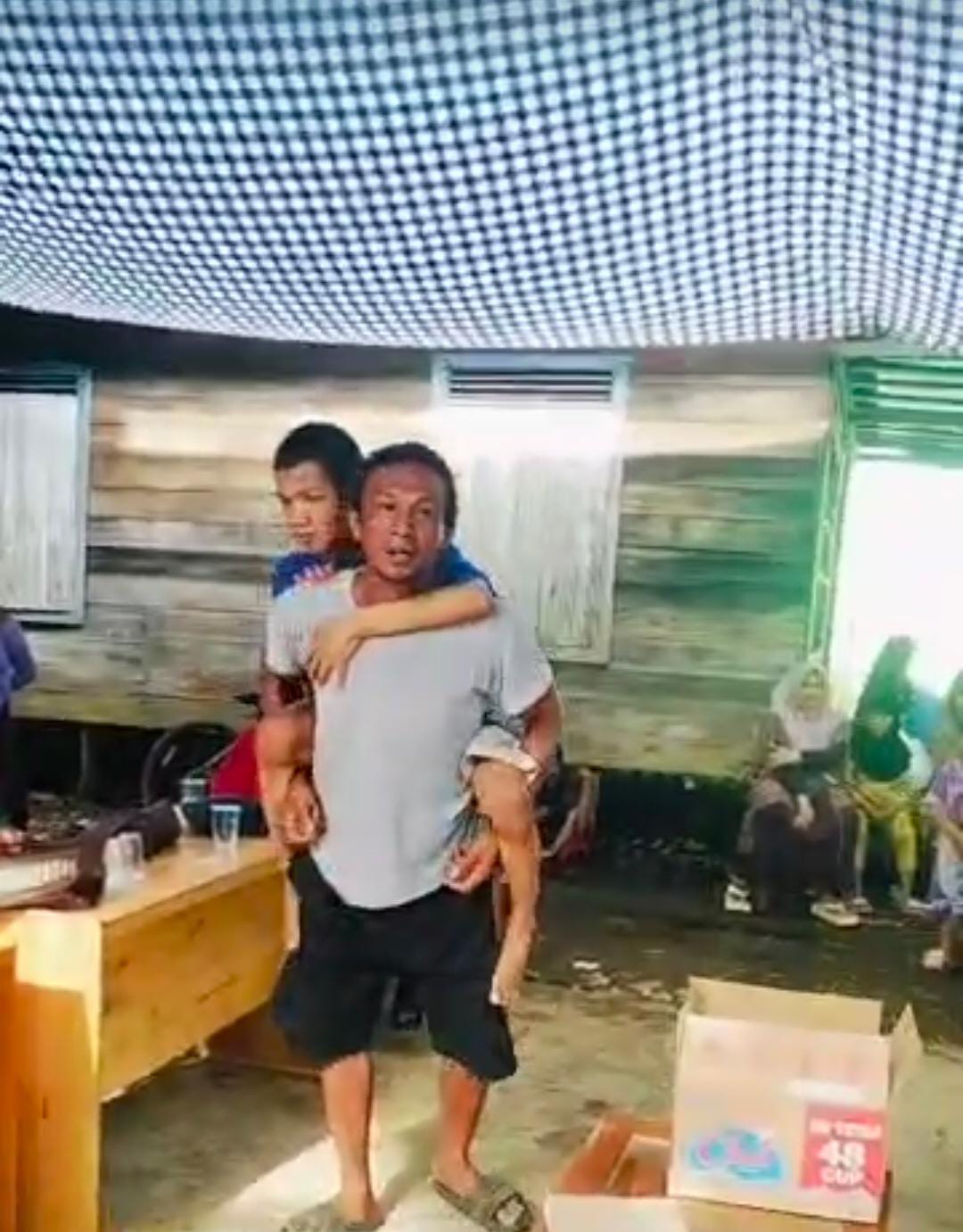 PROTES: Tangkapan layar video warga Murung Abuin menggendong anaknya yang lumpuh saat memprotes penetapan penerima BLT Kesra.