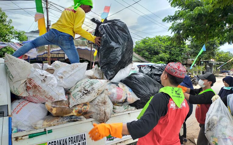 BERSIH-BERSIH: Relawan dan petugas kebersihan mengangkut sampah usai kegiatan keagamaan di Kawasan Sekumpul.
