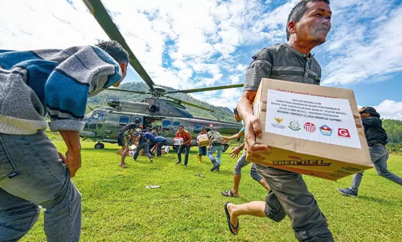 DISTRIBUSI: Warga membawa bantuan di Bener Meria, Aceh, Kamis (4/12). Bener Meriah merupakan satu di antara belasan kabupaten/kota di Aceh yang terdampak banjir bandang.