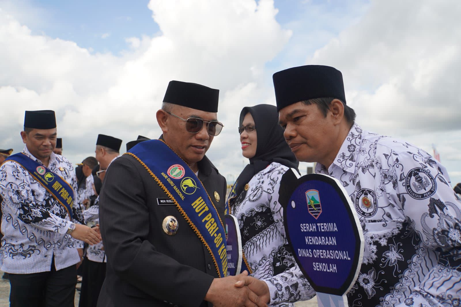 SALAMAN:Bupati Kabupaten Kotabaru, H Muhammad Rusli menyerahkan bantuan kepada perwakilan guru di acara Hari Guru Nasional (HGN) dan HUT PGRI ke-80 di Siring Laut Kotabaru.