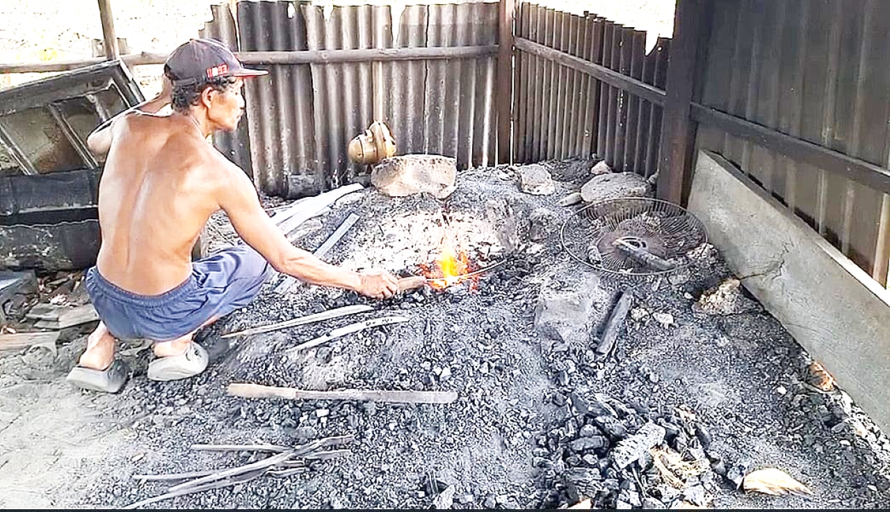 BESI: Wakidi saat mengolah besi untuk membuat berbagai macam benda, Rabu (3/12).