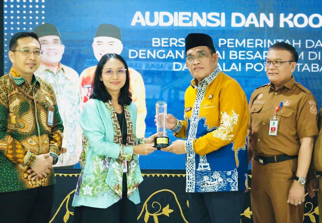 MOMEN:Plt Kepala BPOM Ary Yustantiningsih menyerahkan penghargaan kepada Bupati Kabupaten HSU, H Sahrujani di Mess Negara Dipa, Kota Amuntai Senin (8/12/2025).