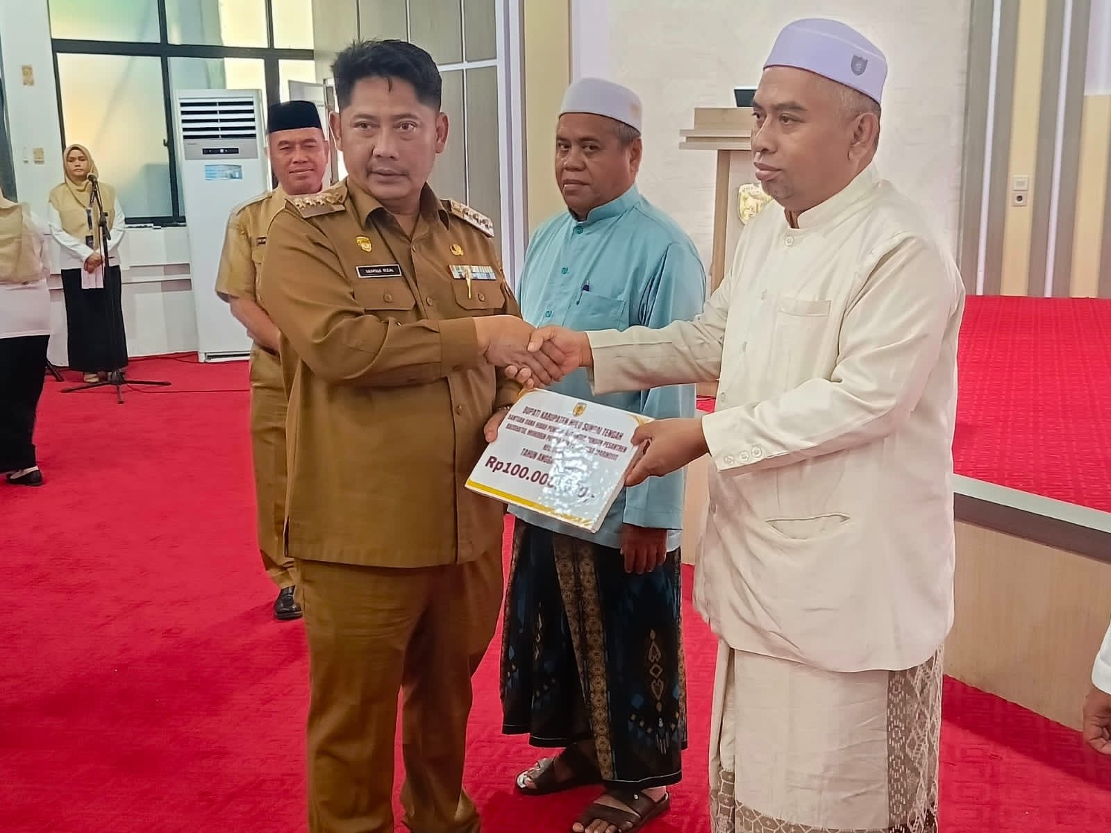 HARUS TRANSPARAN:Bupati Kabupaten HST, Samsul Rizal menyerahkan dana hibah kepada salah satu perwakilan masyarakat.