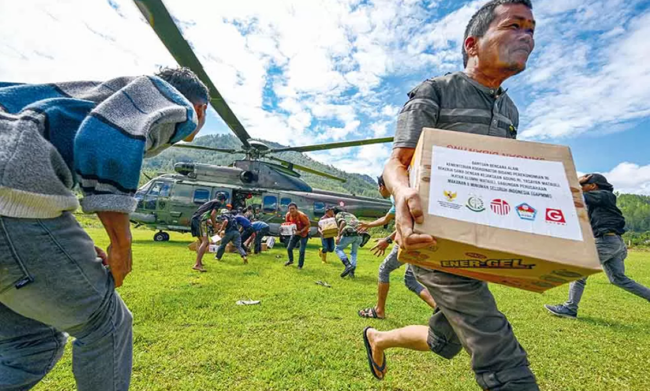 DISTRIBUSI: Warga membawa bantuan di Bener Meria, Aceh, Kamis (4/12). Bener Meriah merupakan satu di antara belasan kabupaten/kota di Aceh yang terdampak banjir bandang.