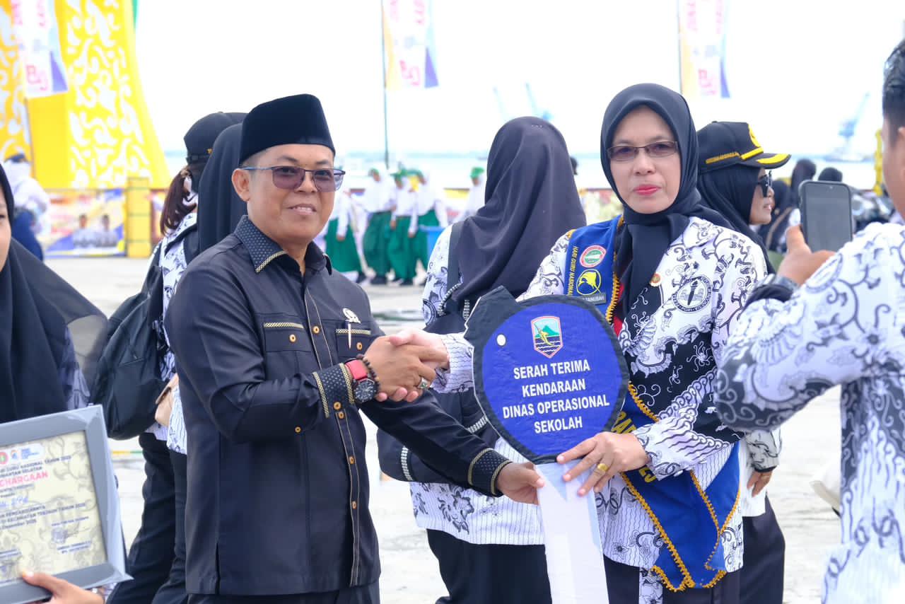 PENYERAHAN:Rahmad, Anggota DPRD Kotabaru Fraksi PAN menyerahkan replika kunci motor secara simbolis ke Ketua PGRI Kotabaru.