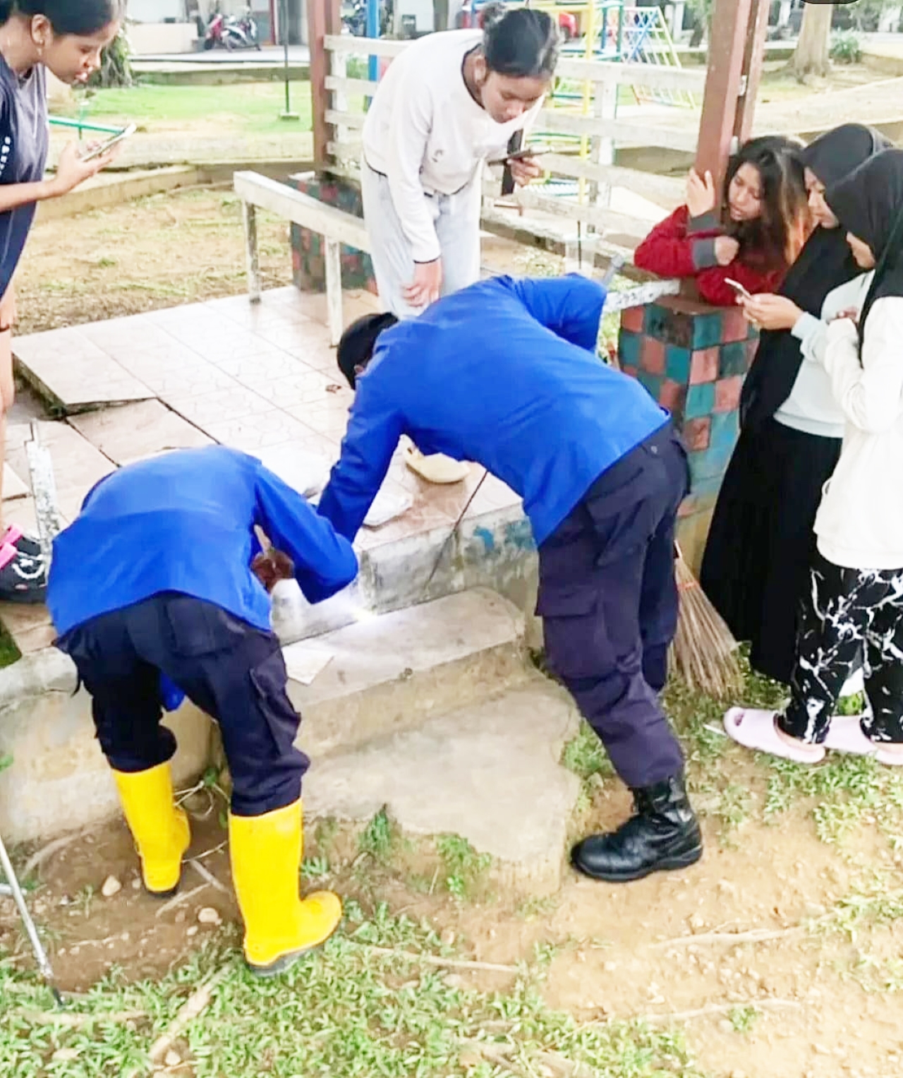 MENGAMBIL PONSEL: Petugas Damkar Banjarbaru saat membantu mengambilkan ponsel milik warga yang masuk ke lubang beton.