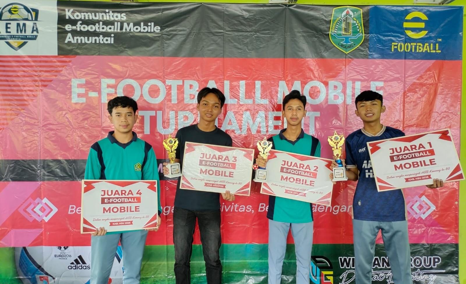 JUARA: Juara 1 turnamen esport football Subahan (baju biru) saat menerima tropi diserahkan panitia diajang Turnamen Efootball Mobile. (Foto: M.Akbar/Radar Banjarmasin).