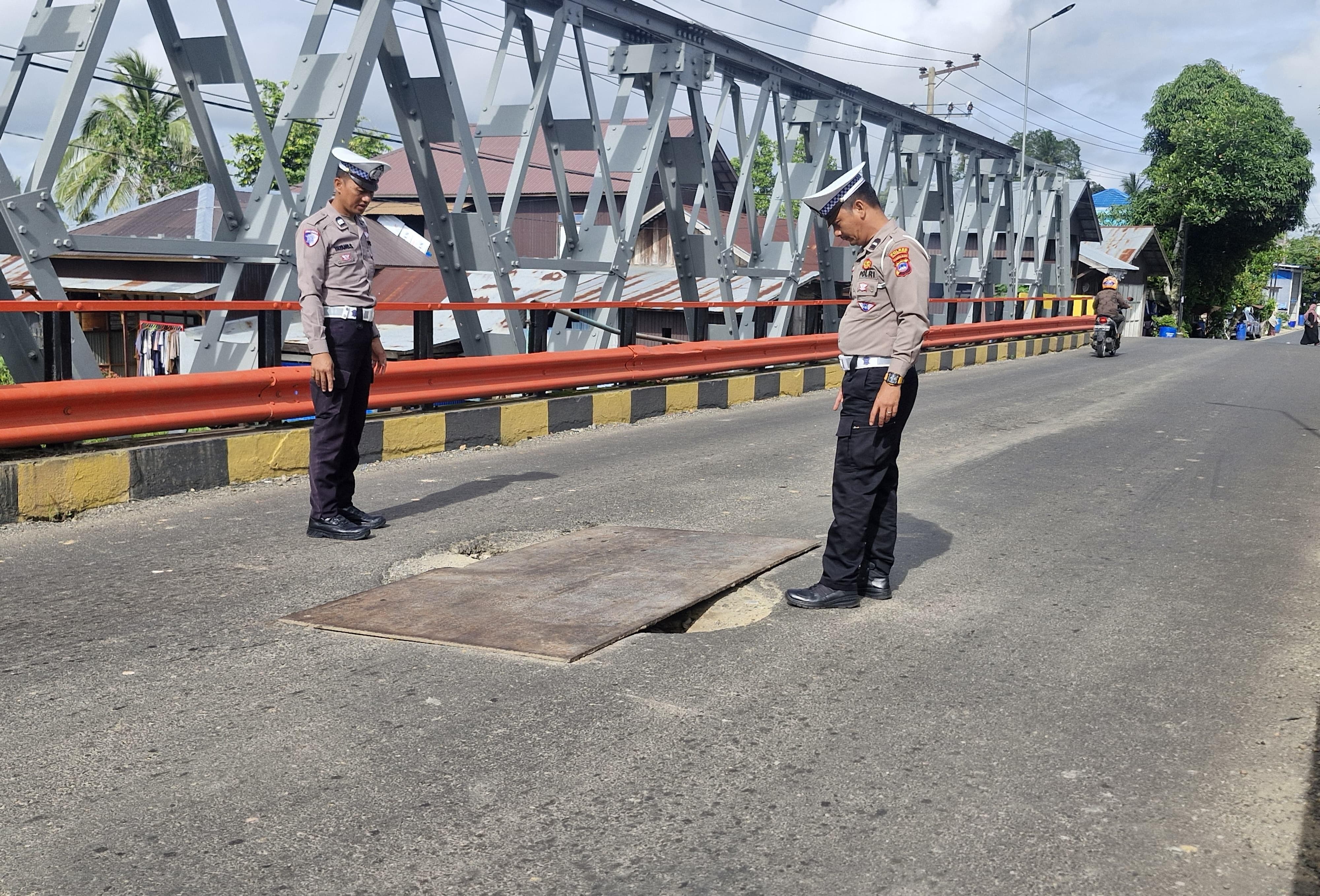 BAHAYA: Anggota Satlantas Polres HSU saat mengecek kerusakan badan jalan Jembatan Amuntai-Ambawang di Kecamatan Amuntai Tengah, Kabupaten HSU.