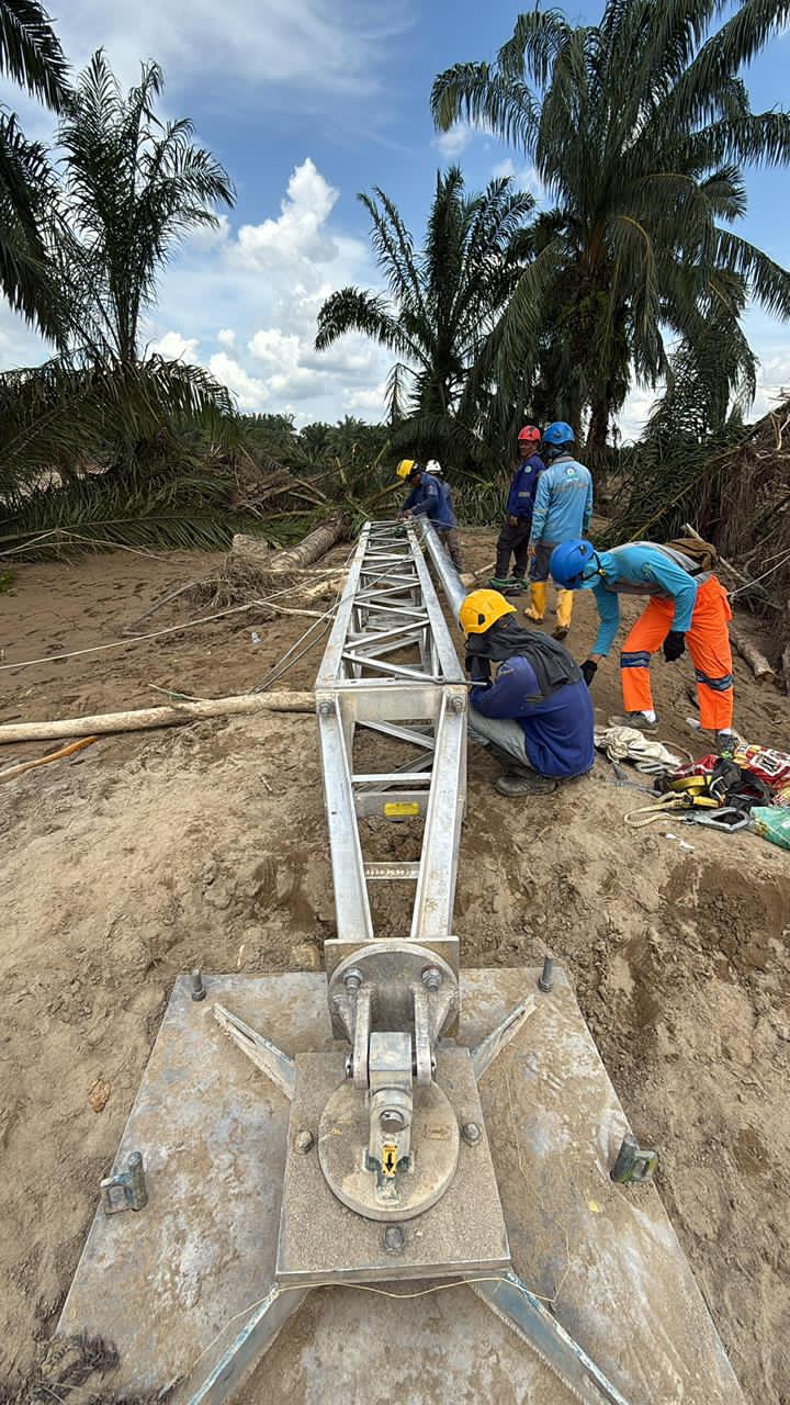KERJA KERAS: Petugas PLN bahu membahu mendirikan tower darurat transmisi Langsa-Pangkalan Brandan 150kV.