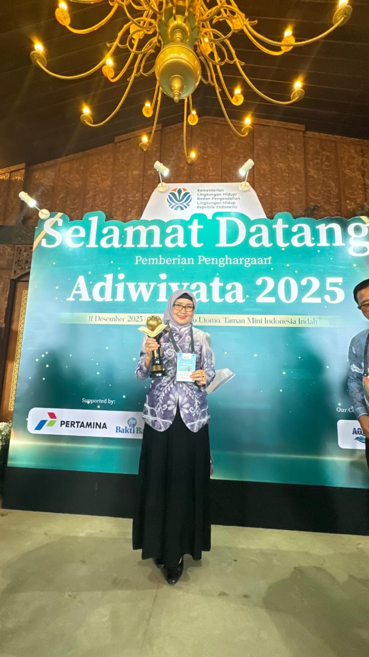 SUKSES: Kepala SMAN 4 Banjarbaru, Dra. Sumini M.Pd memegang Piala Adiwiyata Mandiri usai menerima penghargaan yang diserahkan langsung oleh Menteri Lingkungan Hidup Hanif Faisol Nurofik