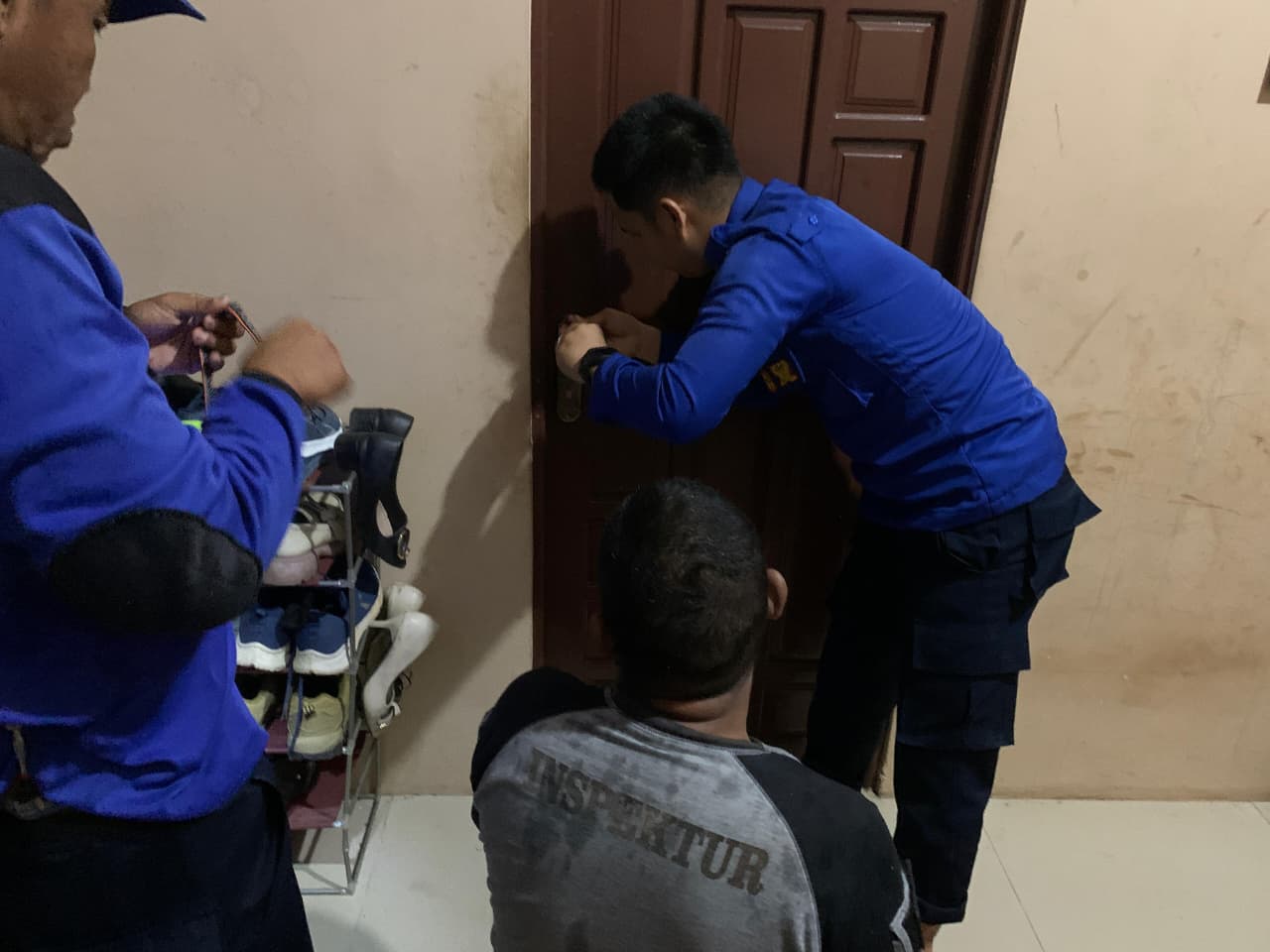 PINTU MACET: Anggota Damkar HSU berupaya membuka pintu kamar yang macet milik kompleks Nusa Indah Kota Amuntai.
