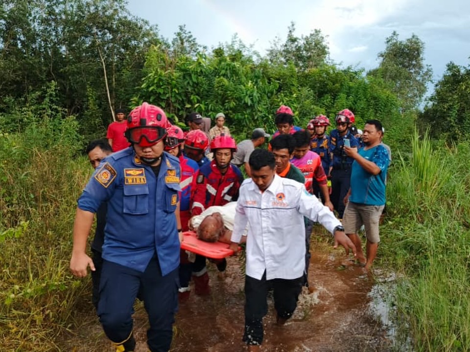 DITEMUKAN: Petugas DPKP Banjar mengevakuasi Gusti Husaini (67) dari area rawa dan persawahan di belakang Kantor BPBD Banjar setelah terpantau drone, Senin (15/12/2025) sore.