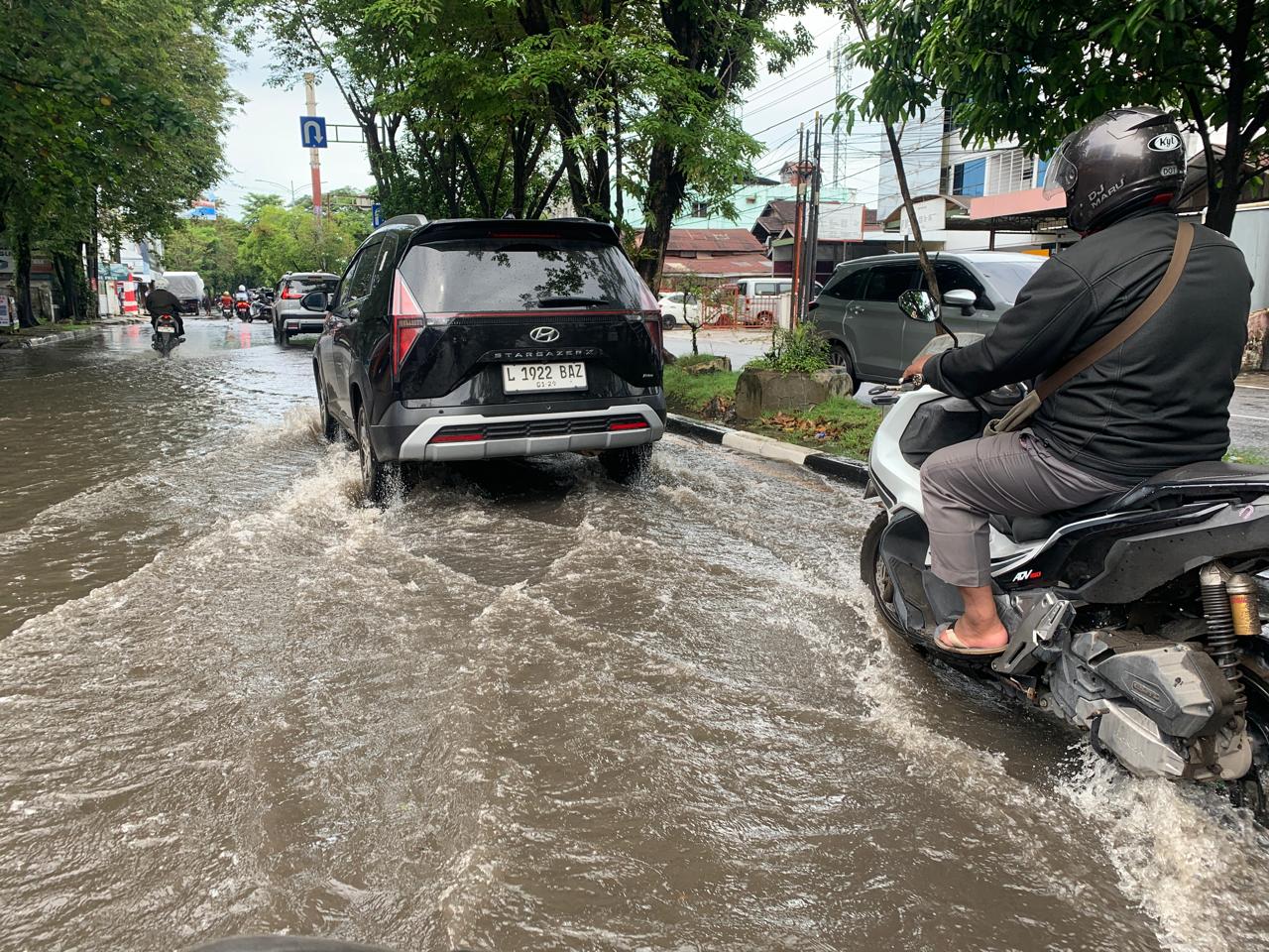 Pengendara mobil dan sepeda motor melintas di genangan air yang menutup badan Jalan Pangeran Antasari, Banjarmasin, akibat hujan deras belum lama tadi. Genangan ini kerap terjadi dan mengganggu kelanc