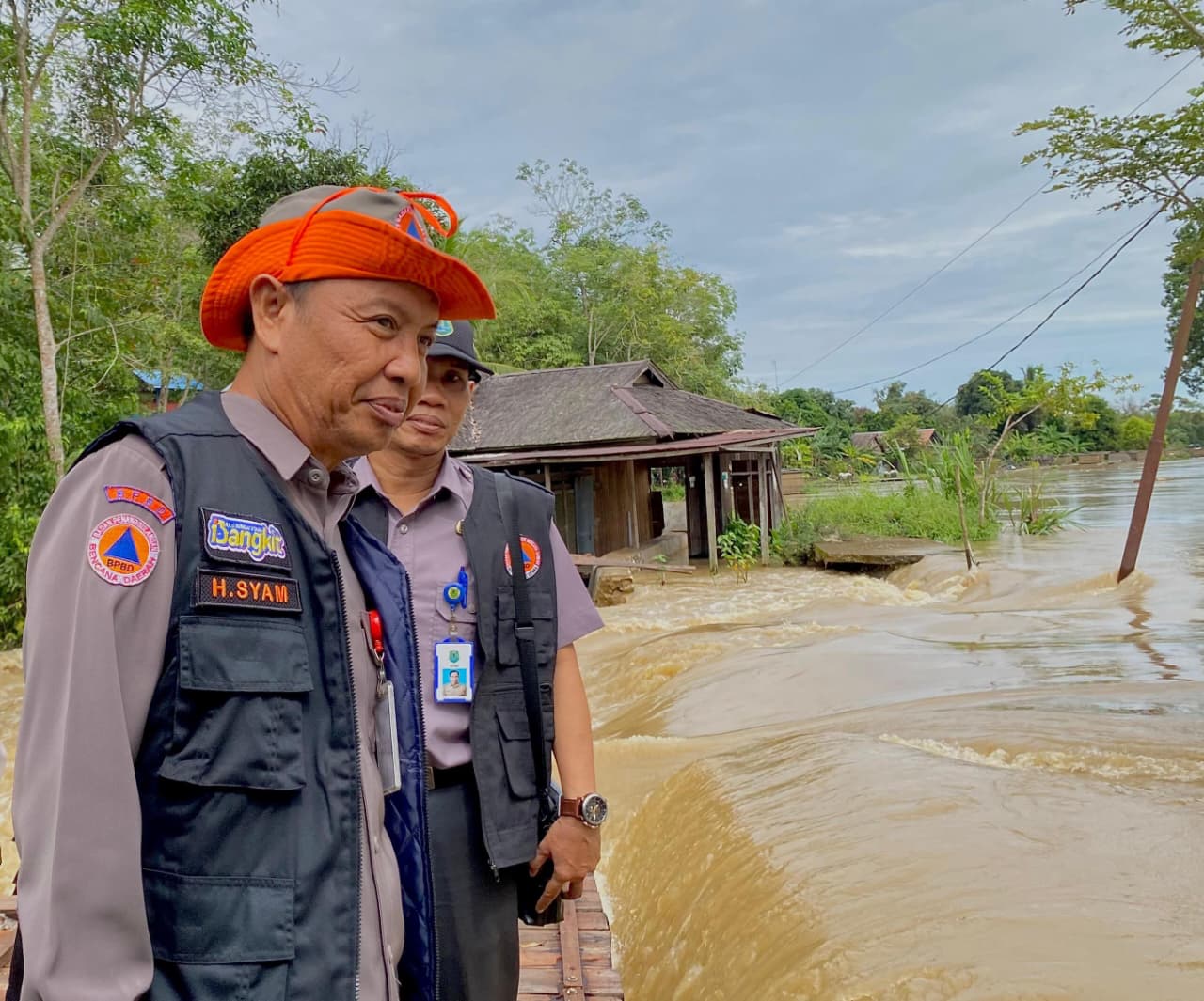 MENDATA: Kepala Pelaksana BPBD HSU H Syamrani melihat langsung lokasi sungai yang meluap dan memutus akses titian di Desa Tuhuran, Kecamatan Haur Gading.