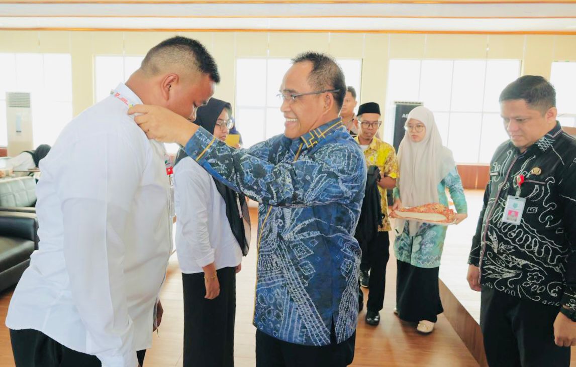 MOMEN:Bupati Kabupaten HSU, H Sahrujani pasang tanda peserta pelatihan peningkatan kapasitas KDKPM di Aula Gedung BPKAD HSU, Kamis (18/12/2025).