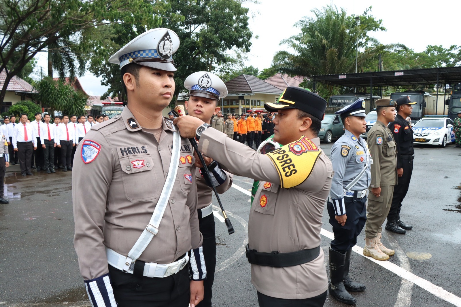 DISIAPKAN : Kapolres Tanah Laut (Tala) AKBP Ricky Boy Siallagan menyematkan pita kepada perwakilan personel yang akan bertugas dalam Operasi Lilin 2025.