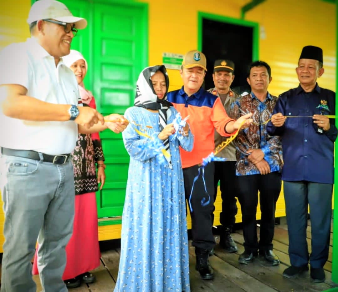 MOMEN:Bupati HSU, H Sahrujani (kiri) potong pita meresmikan program bedah rumah menjadi layak huni bersama Baznas HSU.