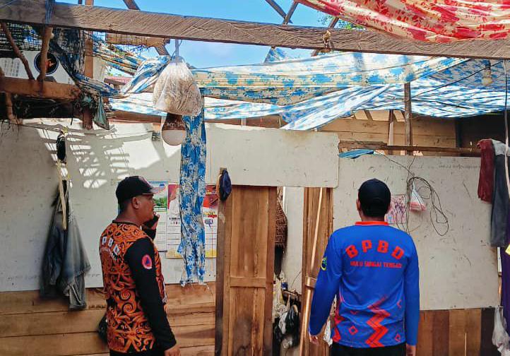 CEK LOKASI: Anggota BPBD HST meninjau lokasi rumah warga yang disapu angin puting beliung.