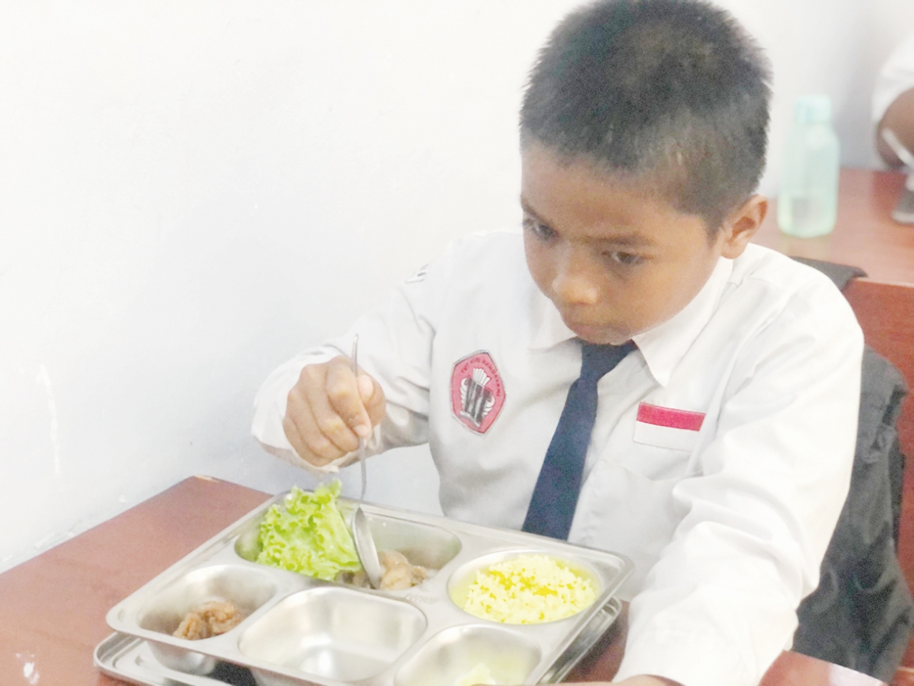MENYANTAP: Seorang siswa saat menyantap makanan bergizi gratis yang disalurkan di salah satu sekolah di Banjarbaru.
