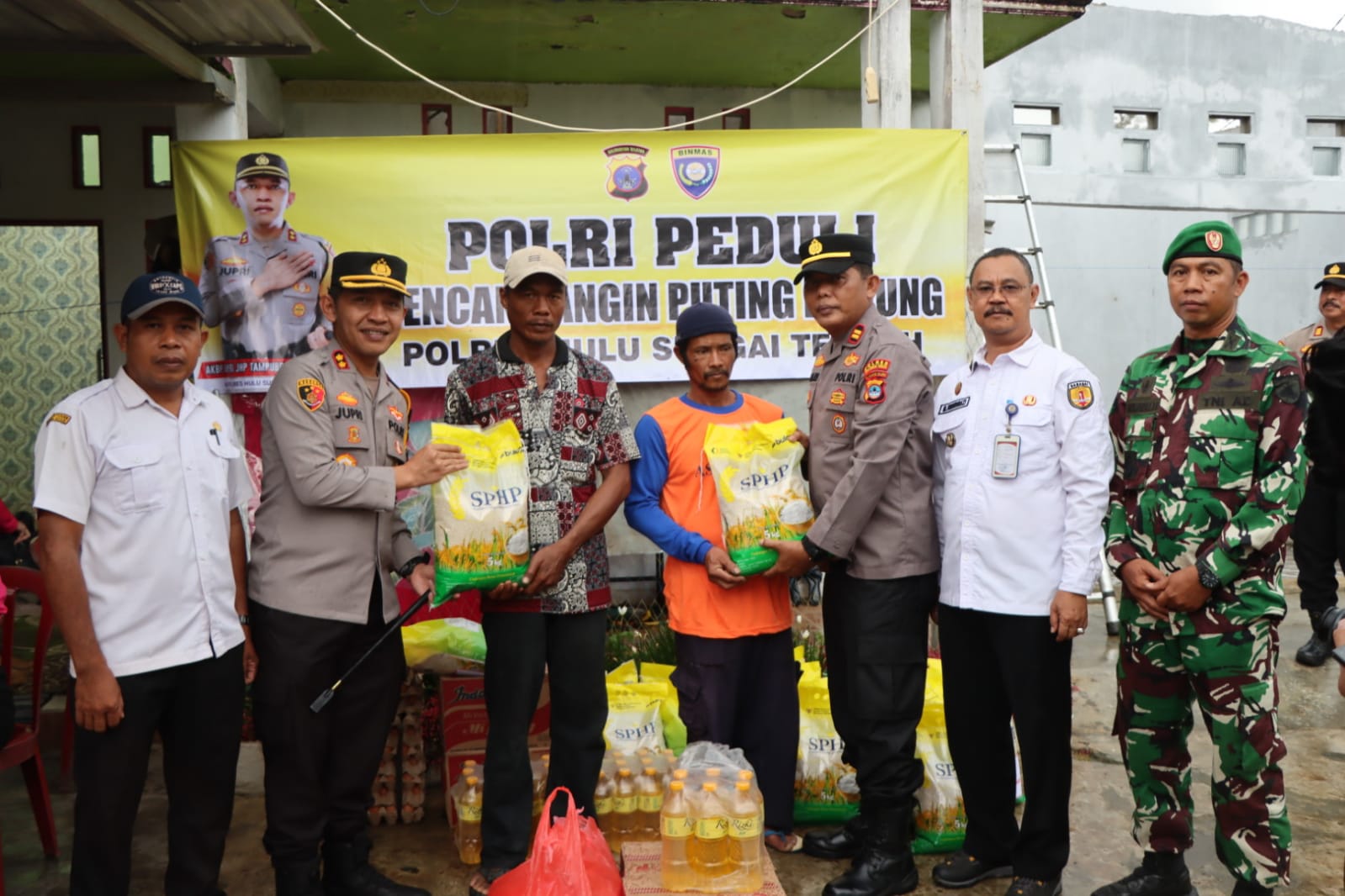 BANTUAN: Kapolres HST, AKBP Jupri JHP Tampubolon (dua dari kiri) menyerahkan bantuan sosial korban bencana. (Foto: Jamaluddin/Radar Banjarmasin).