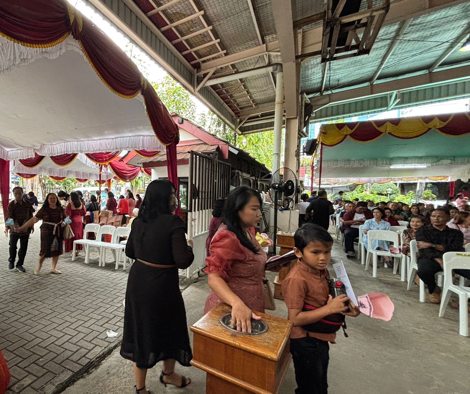 AIR SUCI: Umat Kristiani menyentuh air suci sebelum memasuki gereja, prosesi misa akan berlangsung malam ini di Banjarmasin. Rabu (24/12/2025).