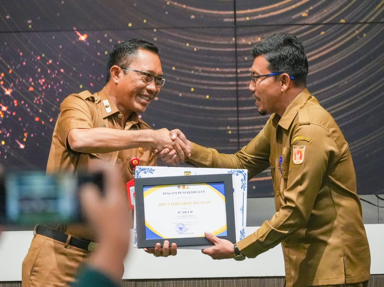 APRESIASI:Plt Kepala DLH Banjarbaru, Sirajoni menyerahkan penghargaan Eco Office, Eco-School, dan Kebersihan Lingkungan 2025.
