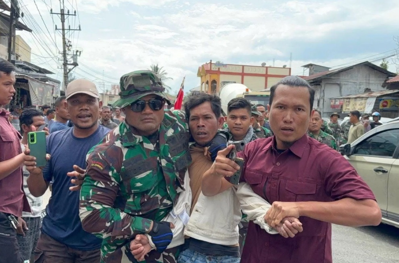 PEMBUBARAN: Prajurit TNI dari Kodam Iskandar Muda mengamankan salah seorang massa aksi pengibaran bendera GAM pada Kamis (25/12).