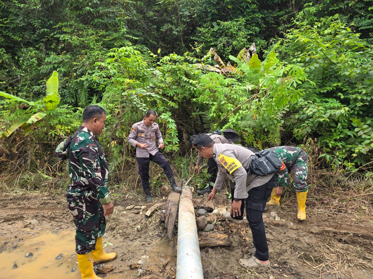 PERBAIKI: Tim gabungan TNI-Polri, PLN dan warga gotong royong melakukan perbaikan tiang listrik yang roboh.