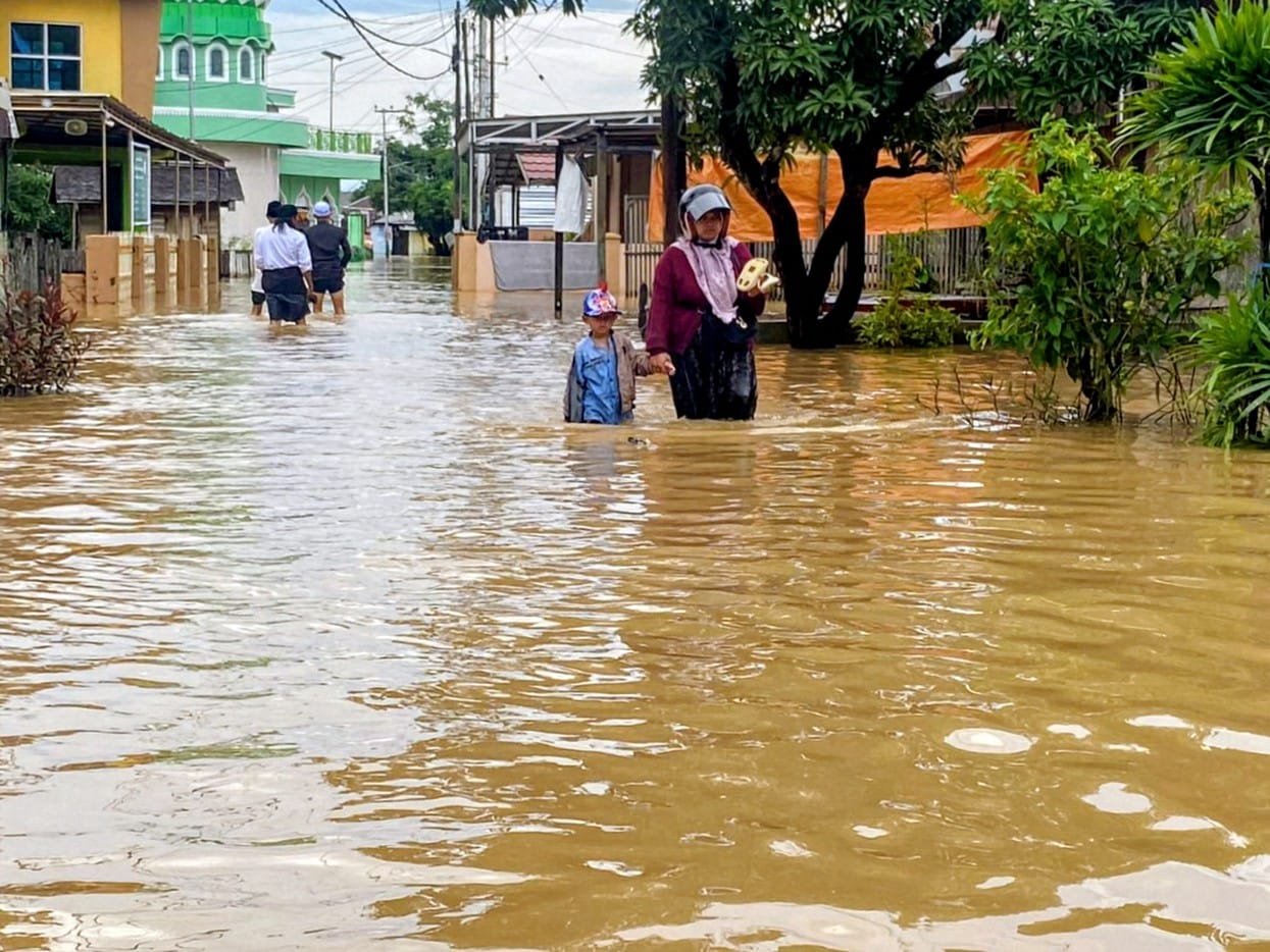 TERENDAM: Warga Desa Dalam Pagar, Kabupaten Banjar terobos banjir yang merendam pemukiman penduduk pada Senin (29/12/2025) sore.
