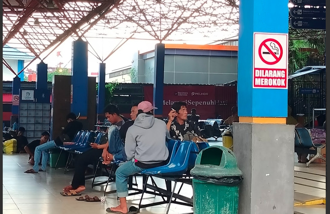 SEBAT DULU: Salah seorang penumpang di ruang tunggu Pelabuhan Trisakti Banjarmasin bisa merokok tanpa harus takut ditegur petugas. (Maulana/Radar Banjarmasin)