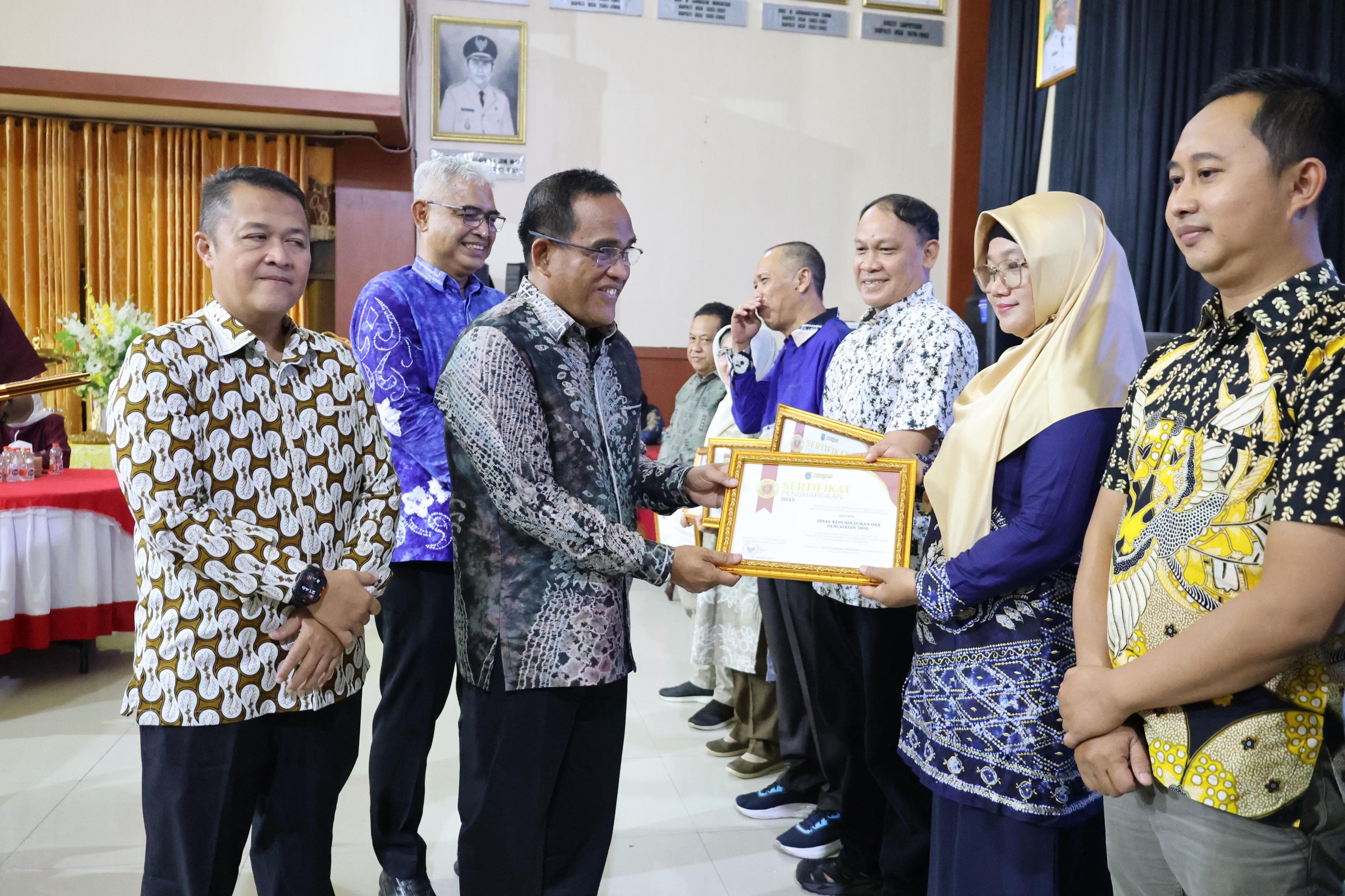 MOMEN:Bupati HSU H Sahrujani, menyerahkan penghargaan IGA 2025 kepada Kabid Pemanfaatan Data dan Inovasi Pelayanan, Yayuk Sri Suwartiningsih, mewakili Kadisdukcapil HSU Tony Fitriady.
