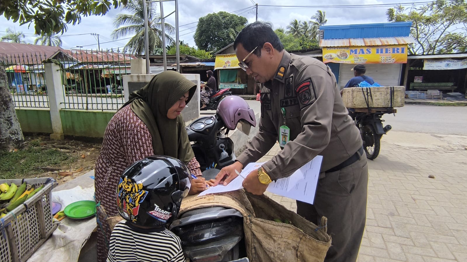TEGURAN: Salah satu PKL menandatangani surat teguran usai penertiban Satpol PP di kawasan Pasar Modern Adaro Paringin, Selasa (30/12/2025).