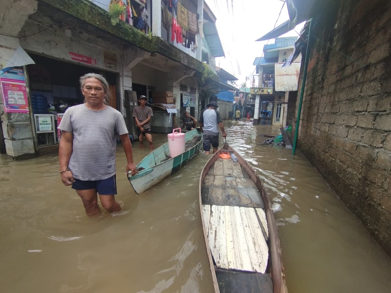 KEBANJIRAN: Warga Murung Keraton, Kabupaten Banjar, membawa sampan kecil untuk menyelamatkan hartanya dari genangan banjir, Selasa (30/12/2025) petang.