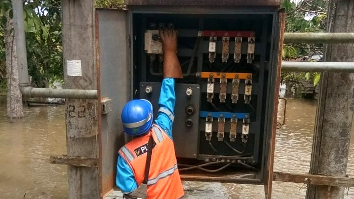 PASTIKAN AMAN:Petugas PLN saat melakukan pengamanan aset kelistrikan seperti gardu distribusi akibat banjir.