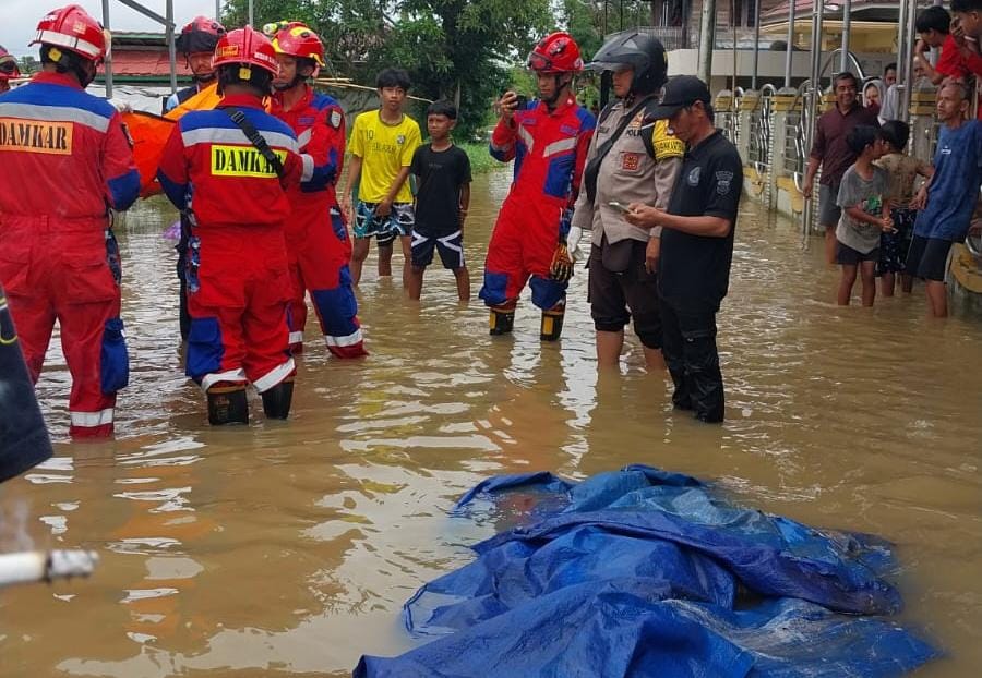 PENEMUAN: Penanganan mayat laki-laki tanpa identitas ditemukan tersangkut di kolong rumah warga di bantaran Sungai Martapura, Kamis (1/1/2026).