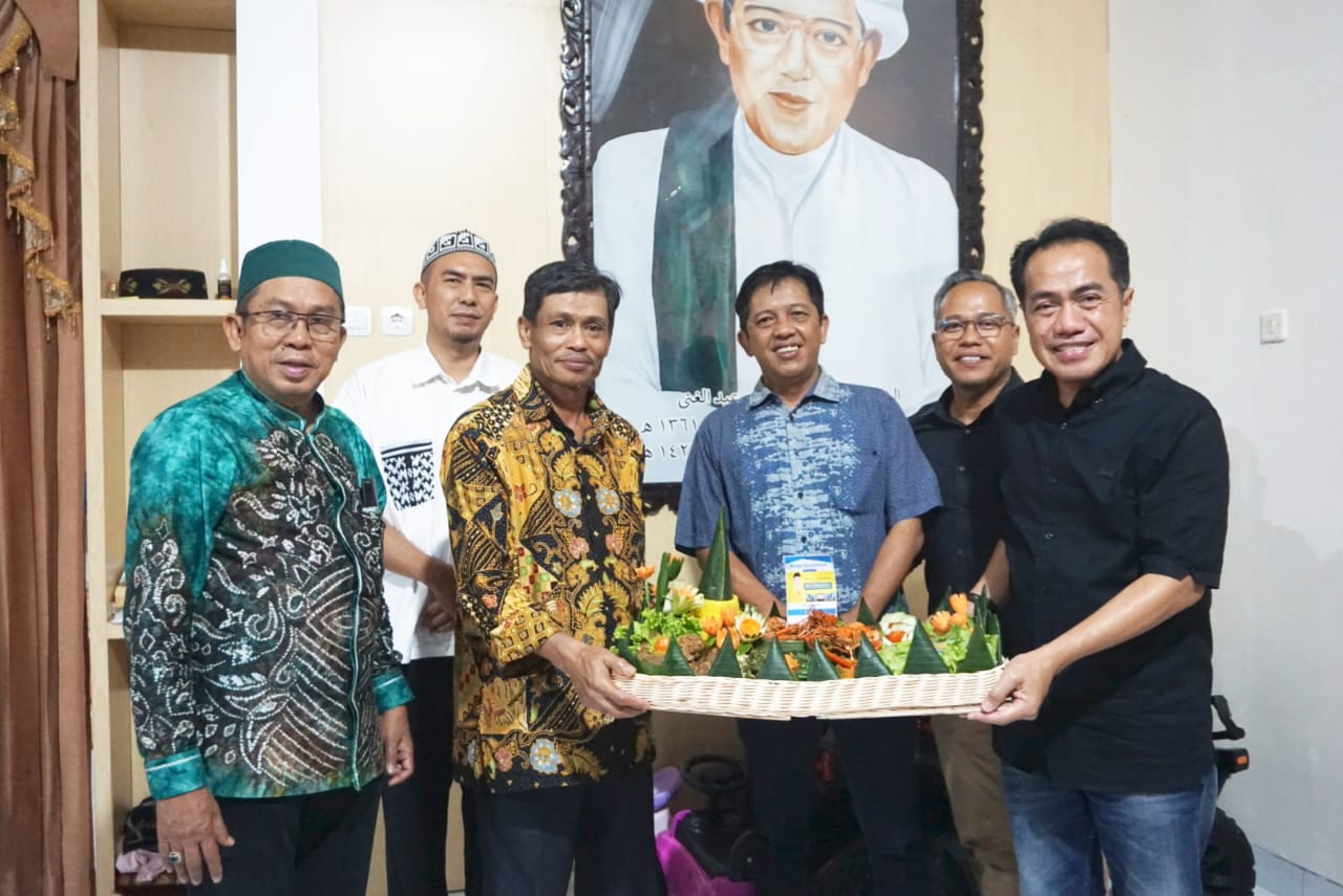TUMPENG: Direktur Utama Radar Banjarmasin H Suriansyah Achmad menyerahkan nasi tumpeng sebagai ucapan Hari Ulang Tahun ke-58 kepada Rektor ULM Prof Dr H Ahmad Alim Bachri,