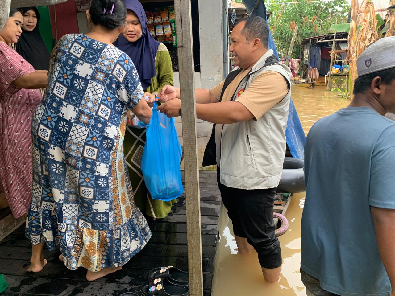 MENYUSURI: Rahmat Saleh menyusuri rumah-rumah warga yang terendam banjir, menyerahkan bantuan sembako, serta menyapa masyarakat terdampak di Desa Tambak Baru, Kecamatan Martapura, Sabtu (3/1/2026).
