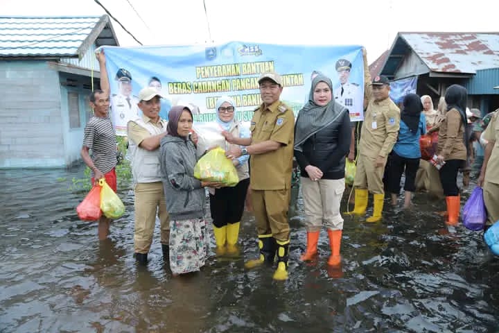 SERAHKAN:Bupati HSS serahkan langsung bantuan untuk korban banjir di Desa Balimau.
