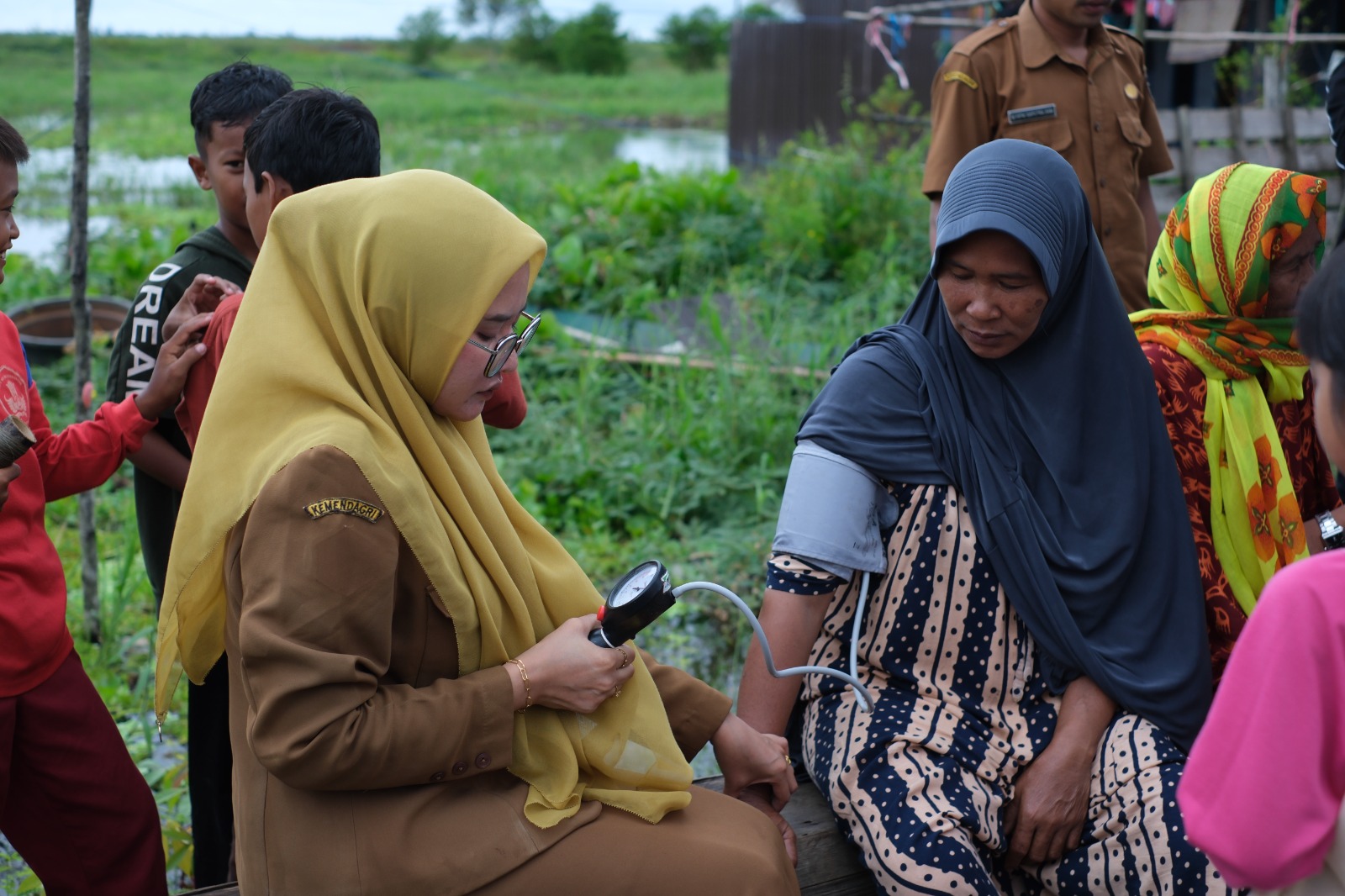 KESEHATAN: Petugas Puskesmas saat memeriksa kesehatan warga terdampak banjir di HST.