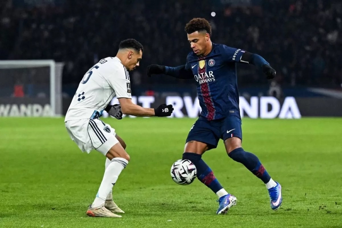 DIHADANG: Pemain PSG Desire Doue dihadang pemain Paris FC Timothee Kolodziejczak, dalam pertandingan Ligue 1 2025/26 pada Senin (5/1).