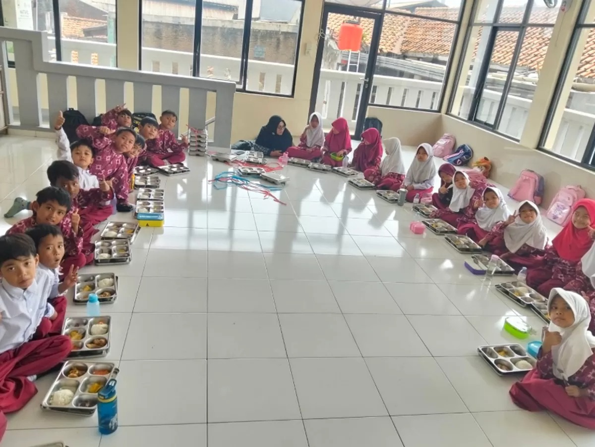 Keceriaan siswa siswi Madrasah Ibtidaiyah (MI) Al-Furqon, Bandung saat menikmati sajian menu Program Makan Bergizi Gratis (MBG).