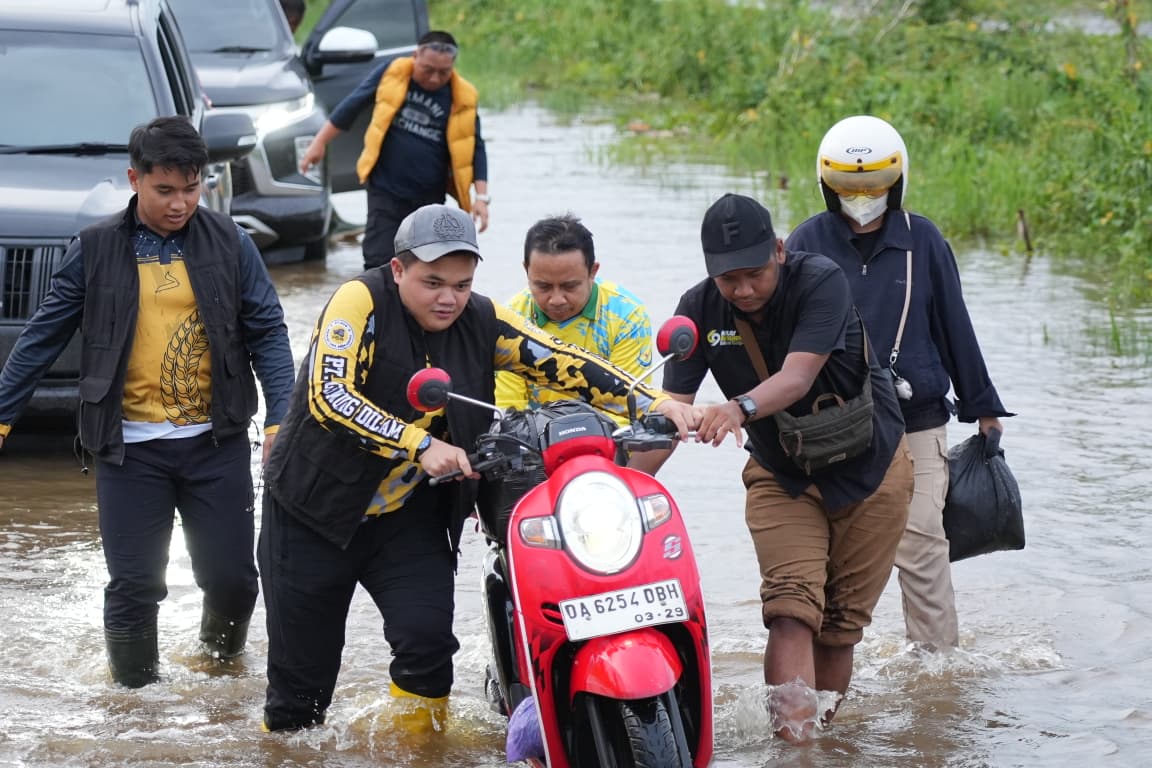 MOGOK: Salah satu pengendara yang kendaraannya mogok didorongkan langsung Bupati Tapin H Yamani saat pemantauan lokasi banjir.