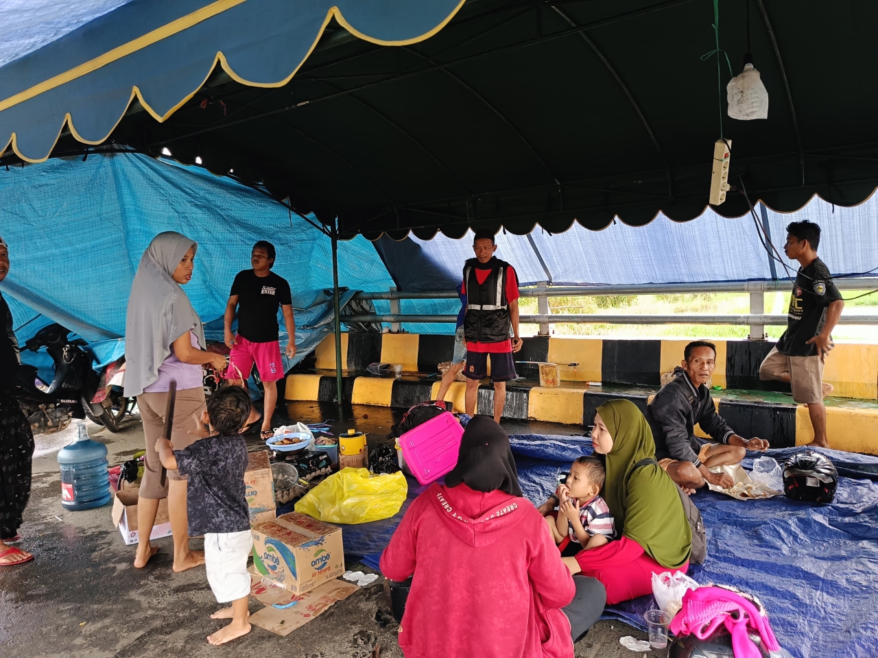 MENGUNGSI: Warga Perumahan Terrace Pelangi memilih mengungsi di atas jembatan agar bisa memantau rumah mereka, Rabu (7/1).