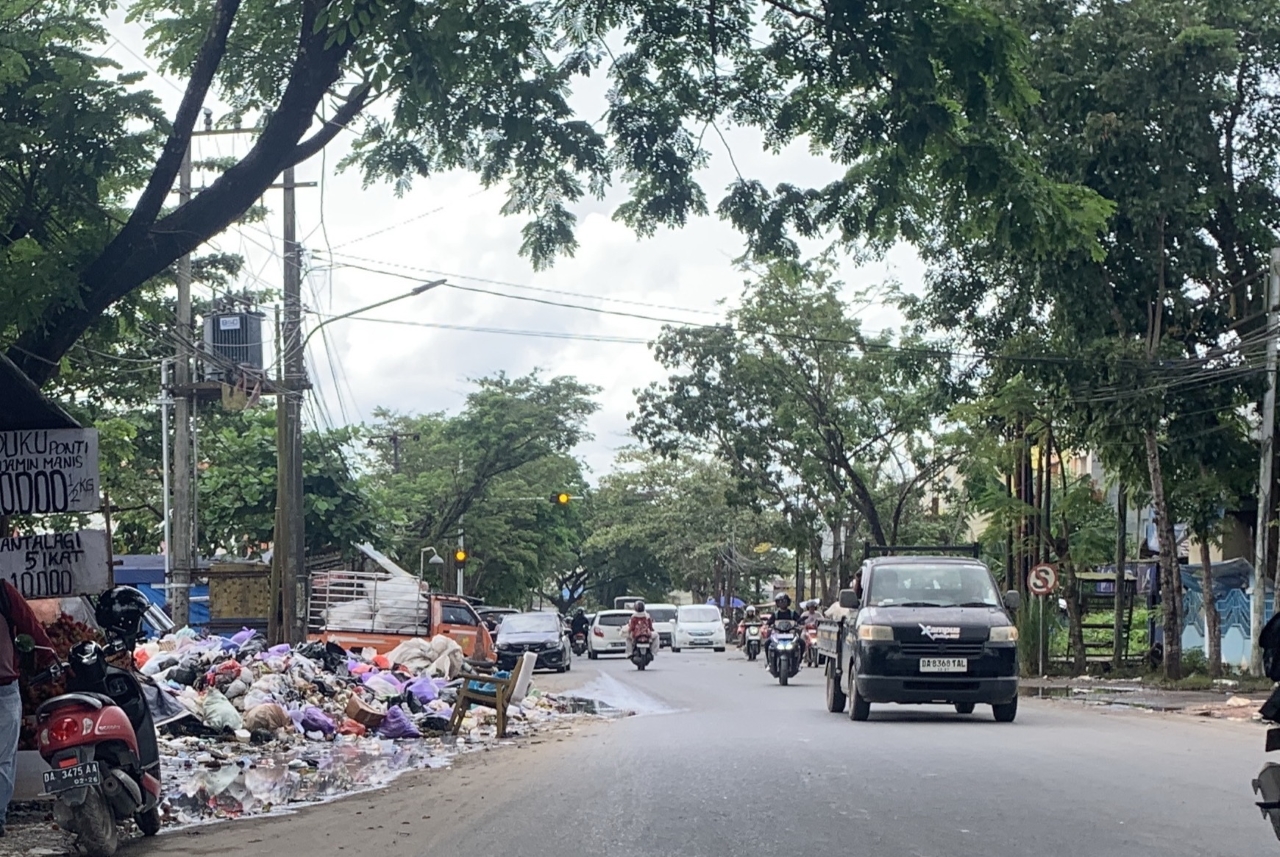 HARUS DITANGANI: Tumpukan sampah meluber hingga ke badan jalan di TPS Jalan Pangeran Hidayatullah, Banjarmasin Timur, Kamis (8/1/2026) siang.
