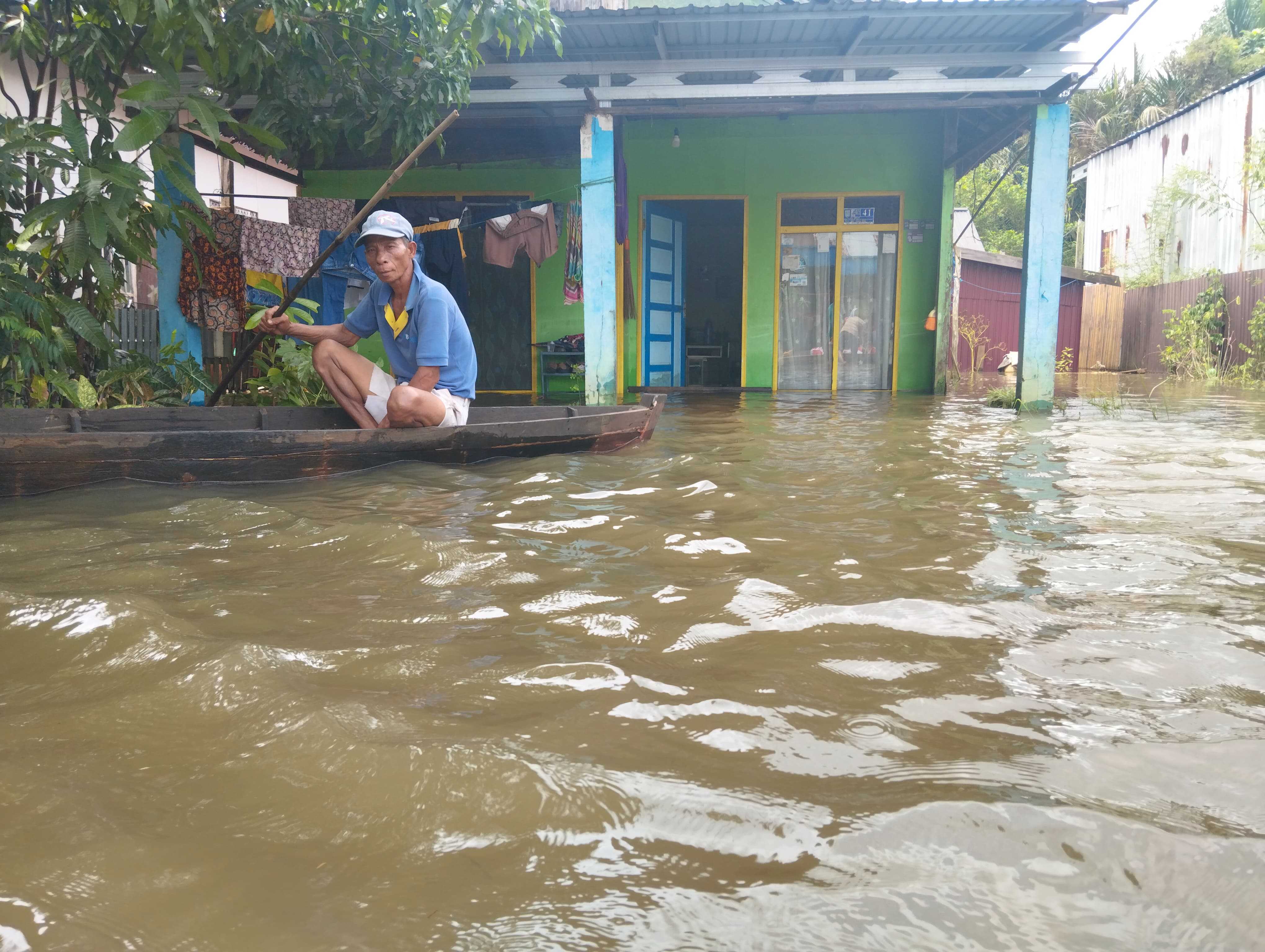 JAGA RUMAH : Warga Desa Sungai Tabuk Keramat, Kecamatan Sungai Tabuk, Kabupaten Banjar, sedang naik sampan di halaman rumahnya. (FADLAN ZAKIRI/RADAR BANJARMASIN)